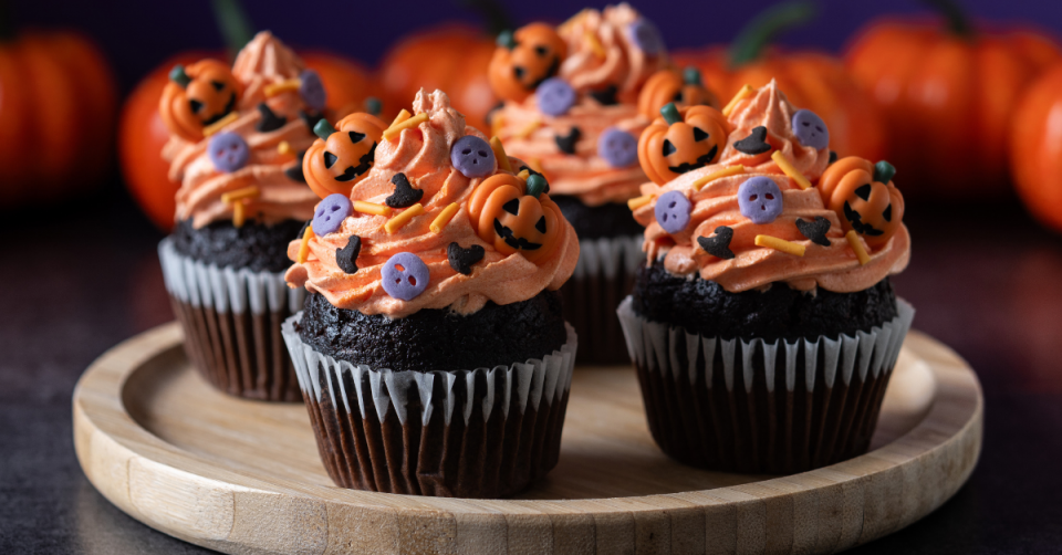 Halloweeni desszertek, színes muffinok egy tálon
